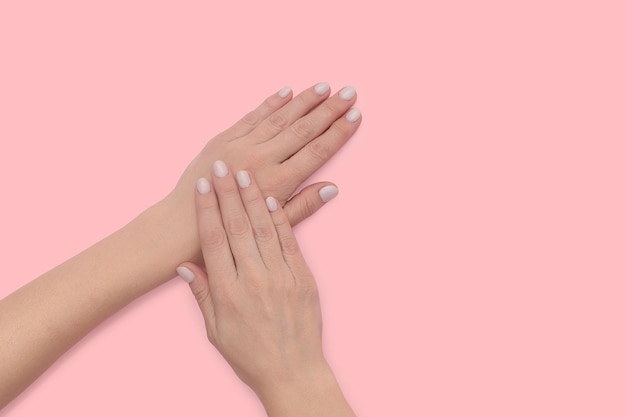 Mãos femininas com uma bela manicure Tratamento e cuidados de spa para a pele das mãos e unhas