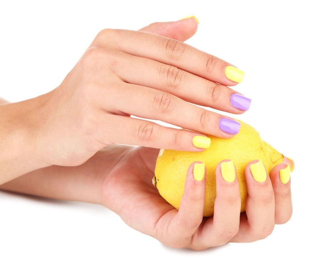 Foto mãos femininas com unhas coloridas e elegantes segurando limão fresco isolado em branco