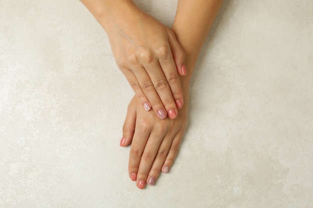 Mãos femininas com unhas rosa