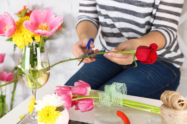 Foto mãos femininas compondo um belo buquê de close-up florista no trabalho foto conceitual