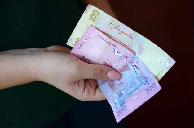 Mãos femininas contam grande quantidade de dinheiro ucraniano durante o período de salário na Ucrânia conceito de vida rica