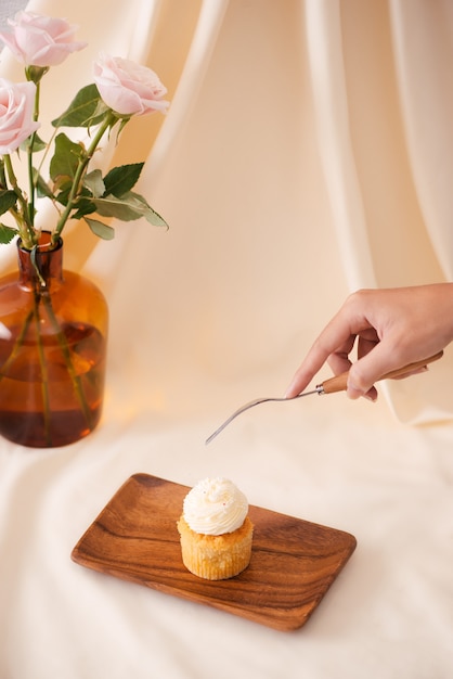 Foto mãos femininas cortam os deliciosos cupcakes na mesa