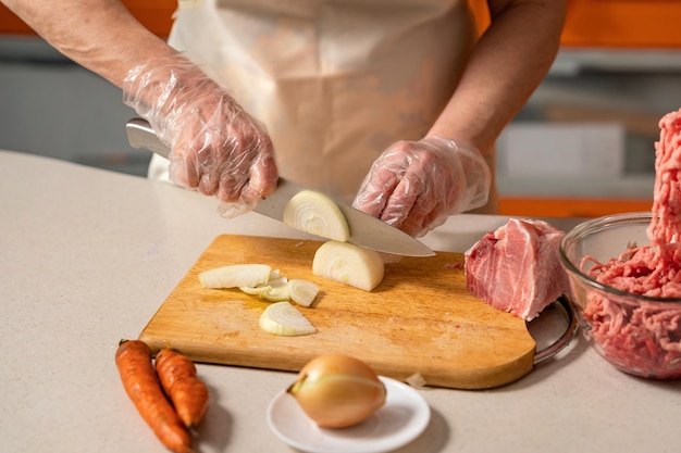 mãos femininas cortando cebola para carne picada