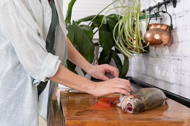 Mãos femininas cortando filé de peixe vermelho caviar vermelho removendo espinhas de peixe massacrando carne de peixe vermelhoxaxafood concept