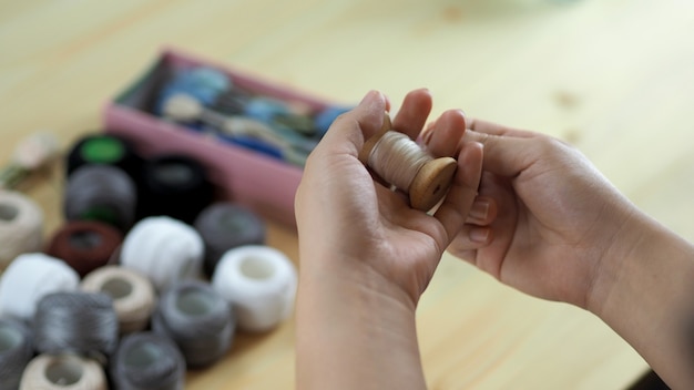 Mãos femininas e trabalhos artesanais bordado costurando à mão trabalho artesanal com linha costurar tricô