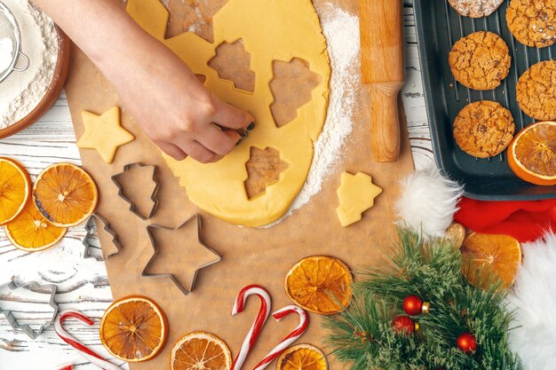 mãos femininas fazendo biscoitos de massa fresca em casa