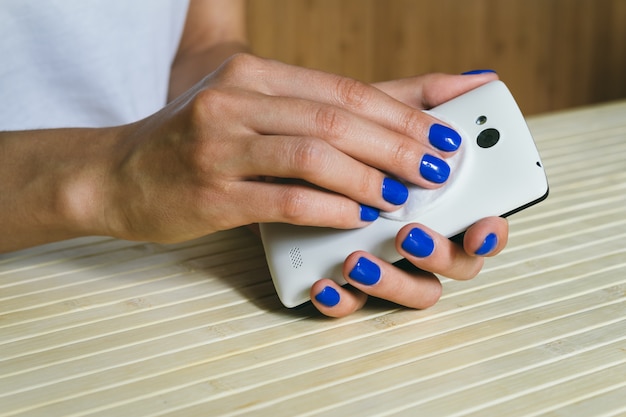 Mãos femininas limpas de poeira e sujeira celular da cor branca