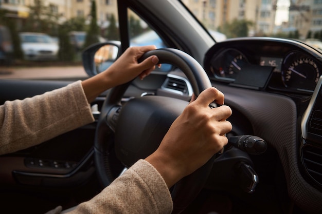 Mãos femininas no volante.