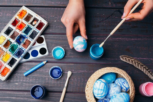 Mãos femininas pintando ovos de Páscoa