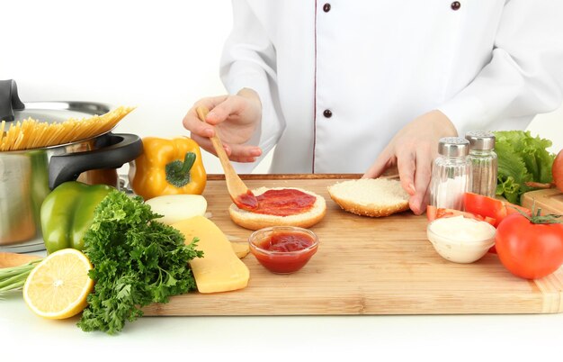 Mãos femininas preparando cheeseburger isoladas em branco