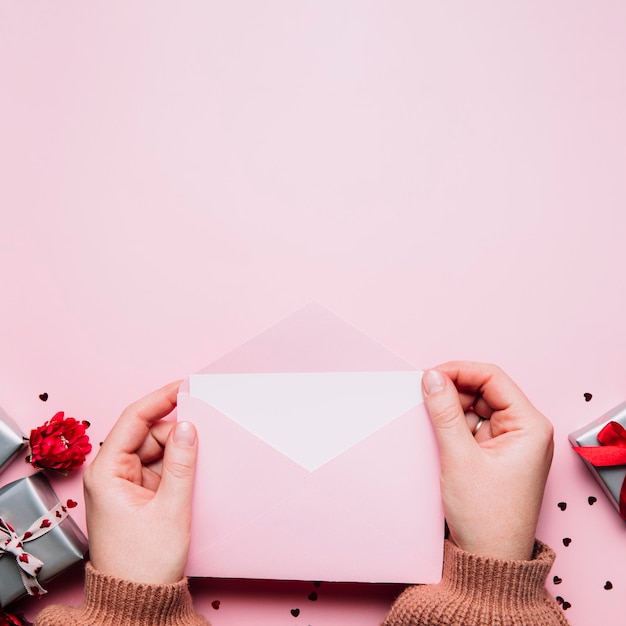 Mãos femininas seguram mensagem de carta de amor em envelope Cartão de saudação do Dia dos Namorados
