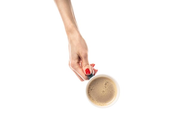 Mãos femininas seguram uma xícara de cerâmica branca sobre fundo branco Xícara de café com café latte cappuccino café three-inone Mãos femininas com manicure vermelha fresca Isolado no fundo branco