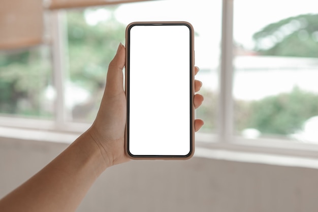 Mãos femininas segurando a tela de espaço em branco da cópia do telefone celular. smartphone com tela branca em branco isolada. telefone inteligente com conceito de tecnologia