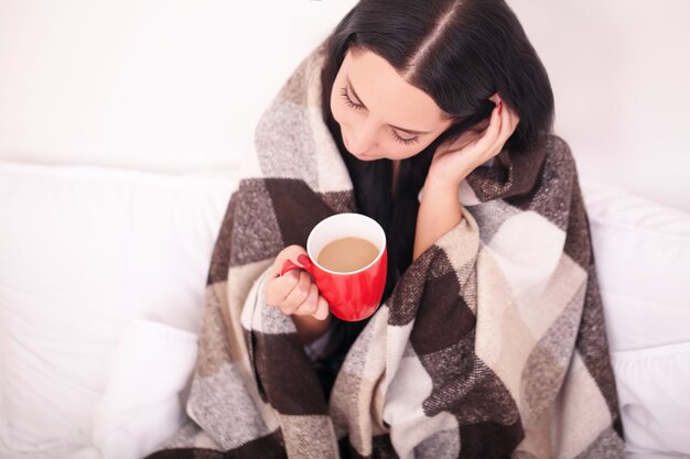 Mãos femininas segurando bebidas quentes de chocolate, inverno e conceito de natal, mulher jovem feliz