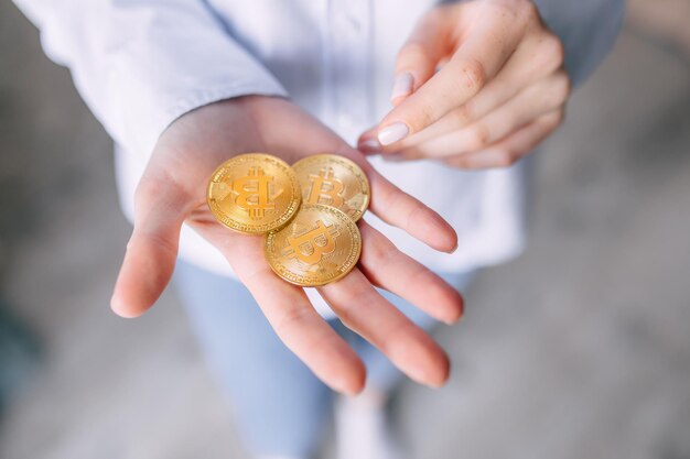 Mãos femininas segurando o Bitcoin virtual