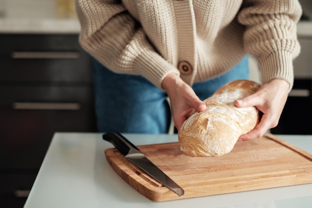 Mãos femininas segurando pão fresco