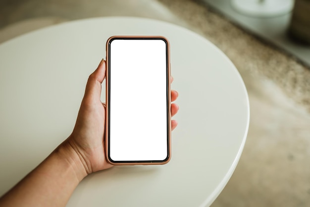 Mãos femininas segurando telefone celular em branco cópia espaço tela telefone inteligente com conceito de tecnologia