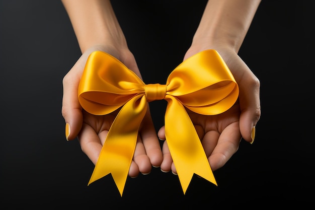 Foto mãos femininas segurando um arco de fita amarela em fundo preto em close-up conceito de celebração