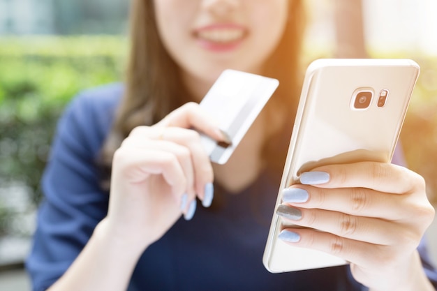 Mãos femininas segurando um cartão de crédito