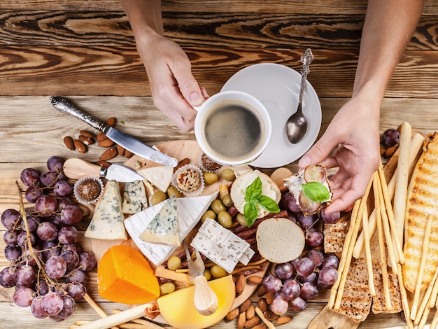 Mãos femininas segurar uma xícara de café e torradas com queijo