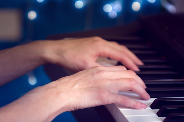 Mãos femininas, tocando, piano