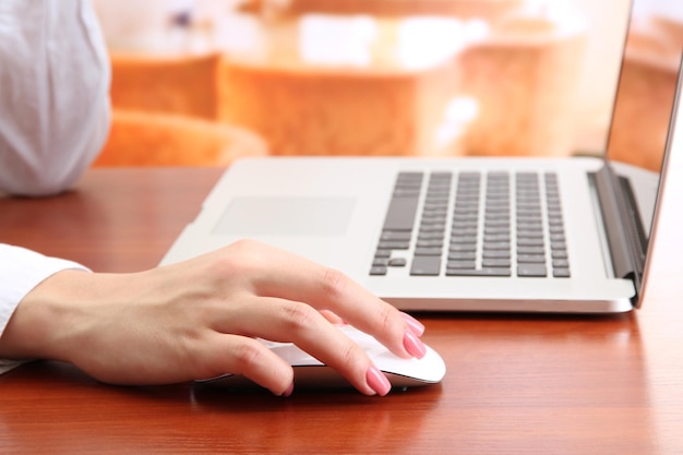 Mãos femininas trabalhando no laptop em fundo brilhante