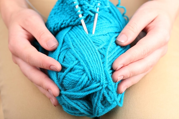Mãos femininas tricotando com raios de perto