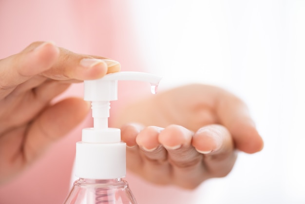 Mãos femininas usando bomba de gel desinfetante para prevenção da doença de Coronavírus (COVID-19)