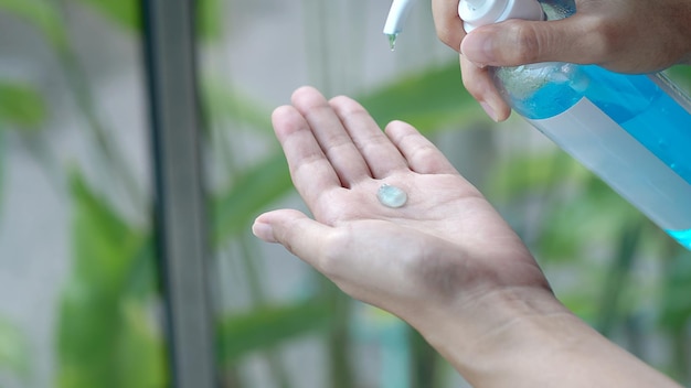 Mãos femininas usando dispensador de bomba de gel desinfetante para as mãos de lavagem