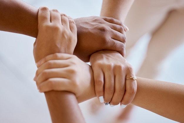 Mãos juntas e solidariedade com um grupo de pessoas fortes na unidade de cima para trabalho em equipe ou colaboração Apoio de confiança e comunidade com uma equipe ou parceria segurando um pulso para motivação