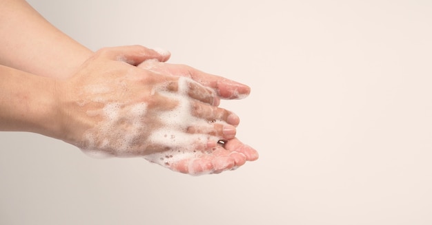 Mãos, lavagem gesto com sabonete de espuma em fundo branco.