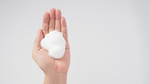 Mãos, lavagem gesto com sabonete de espuma em fundo branco.