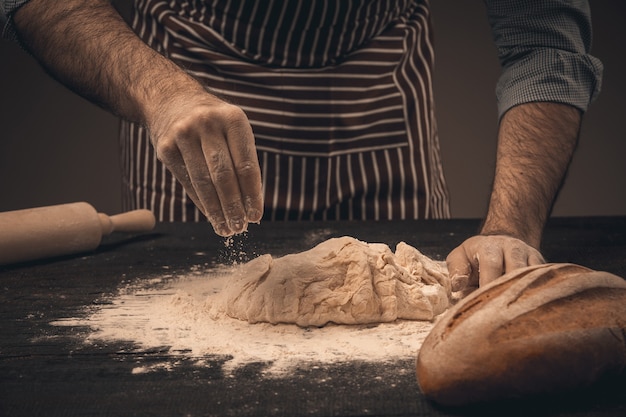 Mãos masculinas amassando a massa