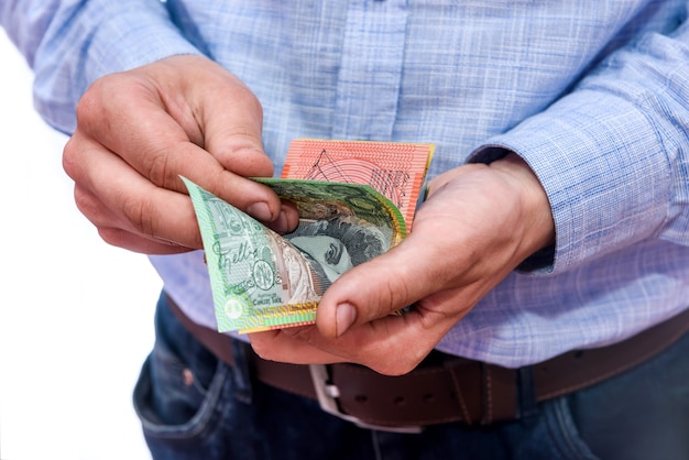 Mãos masculinas contando notas de dólar australiano de perto