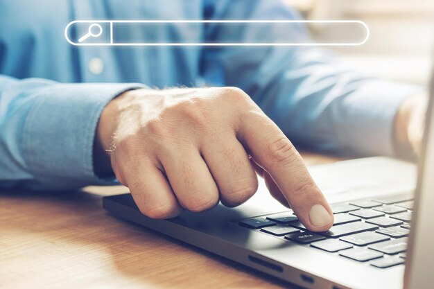 Mãos masculinas digitando em um teclado de laptop, conceito de pesquisa, visualização de close-up