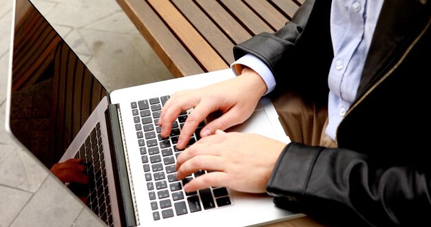 Mãos masculinas digitando no conceito de negócio e tecnologia ao ar livre de teclado de laptop.