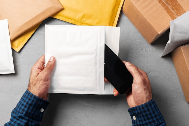 Mãos masculinas embalando envelopes de bolhas para envio