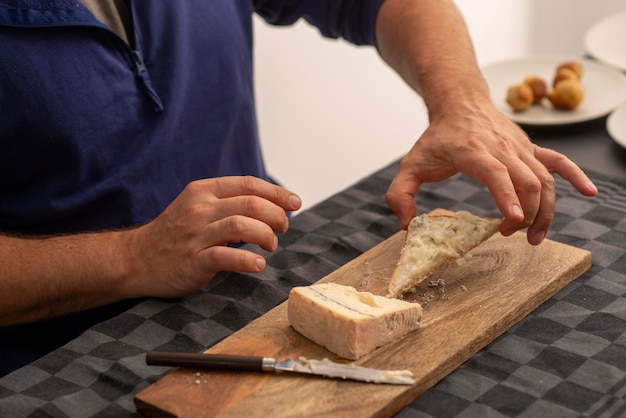 mãos masculinas espalhando queijo macio na torrada
