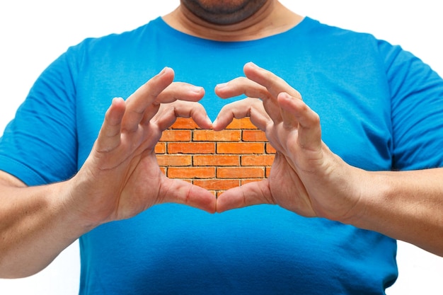 mãos masculinas formando coração com uma parede de tijolo vermelho dentro