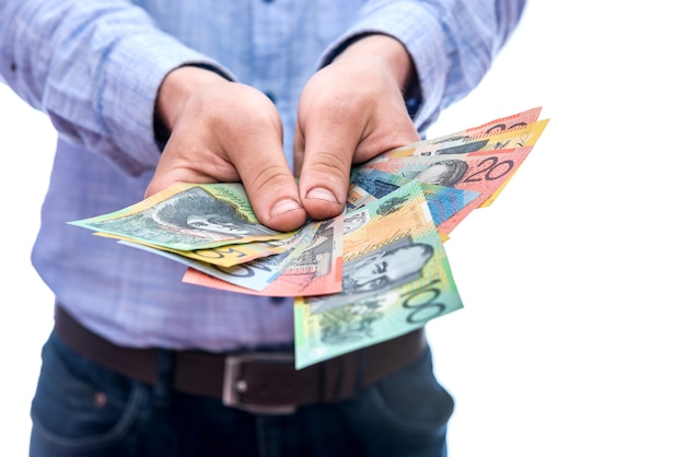 Mãos masculinas mostrando notas de dólar australiano