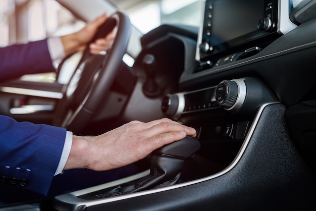 Mãos masculinas no volante, interior do carro