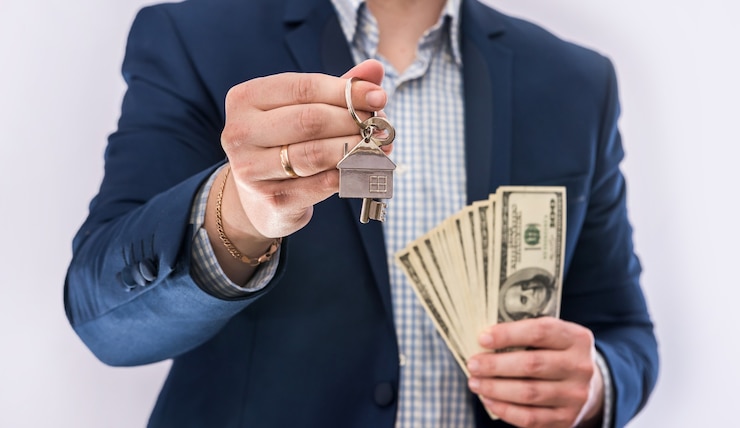 Foto mãos masculinas segurando notas de dólares americanos e a chave da casa isoladas. compra de conceito ou empréstimo imobiliário