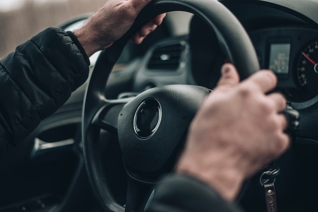 mãos masculinas segurando o volante