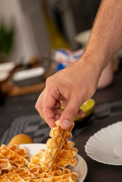 Foto mãos masculinas segurando waffles caseiros