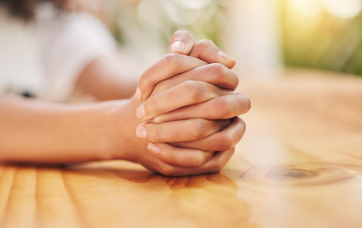 Foto mãos mesa e apertadas para esperar a decisão final esperança de resultados com estresse pessoa feminina palmas e dedos em aperto na mesa com paciência frustrado com ansiedade e tensão