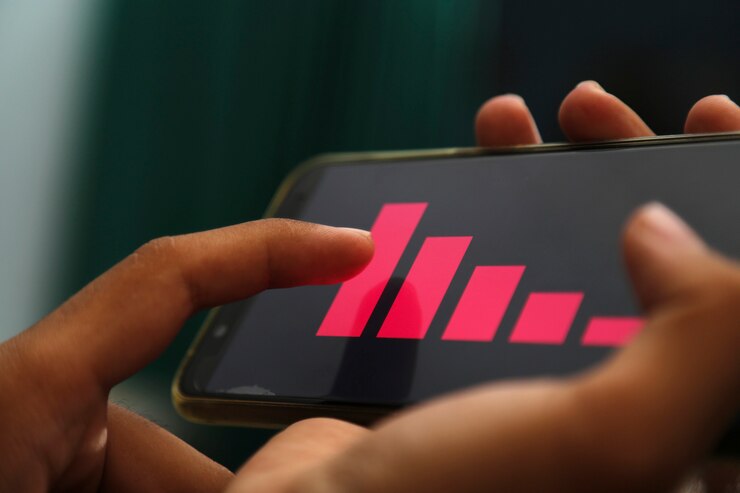 mãos mostrando gráfico de diminuição em um telefone inteligente