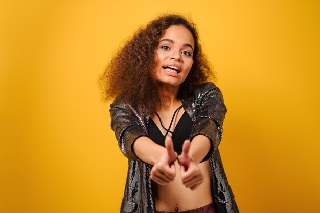 Mãos na frente e polegares para cima, garota afro-americana feliz