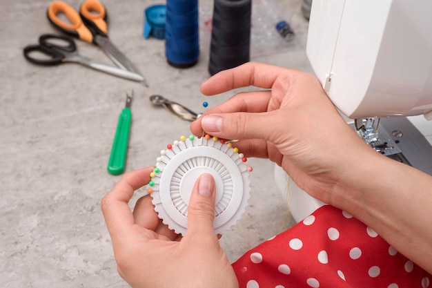 mãos na mulher latina atraente usando máquina de costura além de fabricação de tecidos de fios de tesoura