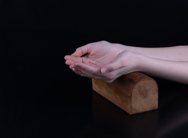 mãos no suporte de oração de madeira