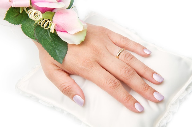 Mãos nupciais com anel de casamento e rosas